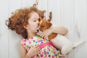 Little girl whispering to her puppy